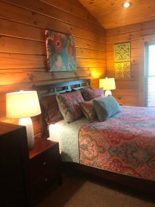 - une chambre avec un lit et deux lampes sur les tables dans l'établissement Swiftwater - Secluded Log Cabin, 