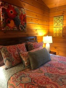 - une chambre avec un lit doté d'oreillers et d'une lampe dans l'établissement Swiftwater - Secluded Log Cabin, 