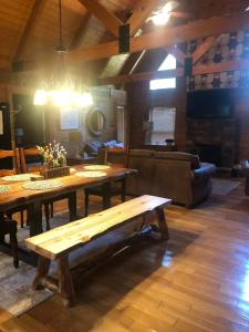 - un salon avec des tables en bois et un canapé dans l'établissement Swiftwater - Secluded Log Cabin, 