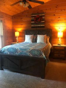 - une chambre avec un lit, 2 tables de nuit et 2 lampes dans l'établissement Swiftwater - Secluded Log Cabin, 