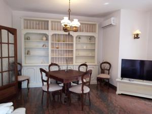 a dining room with a table and chairs and a tv at Villa Daria in Forte dei Marmi