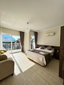 a bedroom with two beds and a large window at Villa Valley Oludeniz, 4 Bedroom, Large Swimming Pool in Fethiye
