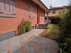 a brick building with orange lines on a driveway at Villa Daria in Forte dei Marmi