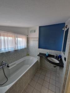 a bathroom with a bath tub and a sink at Mansarda Stefania in Ameglia