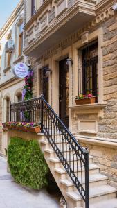 - un bâtiment avec des escaliers et des boîtes de fleurs dans l'établissement Seven Beauties Hotel Spa Restaurant, Old City Baku, à Baku