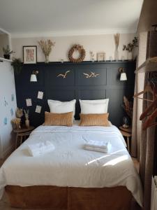 a bedroom with a large bed with two towels on it at un nid d ' Amour in Cabourg