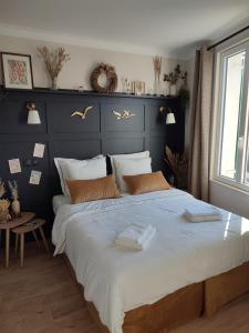 a bedroom with a large bed with a blue headboard at un nid d ' Amour in Cabourg