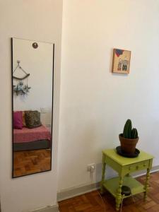 espejo en una habitación con mesa y planta en Apartamento Liberdade, en São Paulo