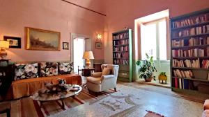 uma sala de estar com um sofá, uma mesa e livros em Foresteria di Casa Winspeare em Depressa