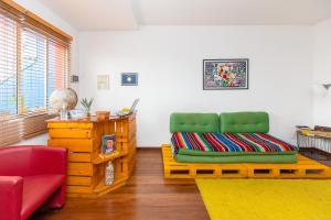 a living room with a green chair and a desk at Hostel Casa Azul in Sao Paulo