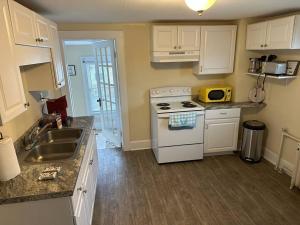 eine Küche mit einem weißen Herd und einer Spüle in der Unterkunft The Yellow Door 3-bedroom downtown near VT&RU in Radford
