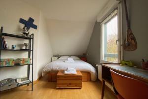 a bedroom with a bed and a cross on the wall at Nice house with pool near the city center in Hérouville-Saint-Clair