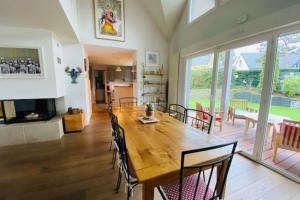 a dining room with a wooden table and chairs at Nice house with pool near the city center in Hérouville-Saint-Clair