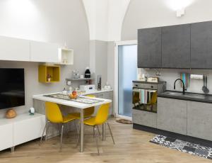 una cocina con mesa y sillas amarillas. en La casa del Pumo en Brindisi