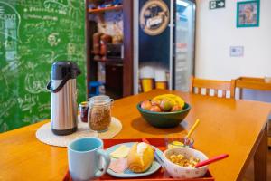 uma mesa com um prato de comida e uma taça de fruta em Hostel Casa Azul em São Paulo