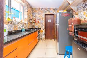 een keuken met oranje kasten en een koelkast bij Hostel Casa Azul in Sao Paulo