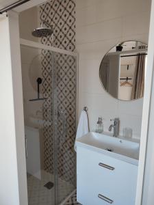 a bathroom with a shower and a sink and a mirror at un nid d ' Amour in Cabourg