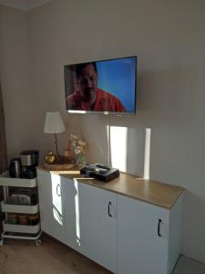 a flat screen tv on a wall with a desk at un nid d ' Amour in Cabourg