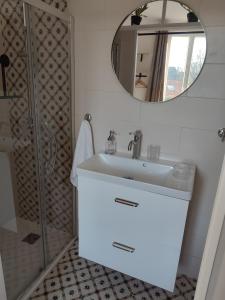a bathroom with a sink and a mirror at un nid d ' Amour in Cabourg