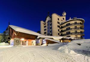 a large building in the snow at night at Principi di Piemonte Sestriere in Sestriere