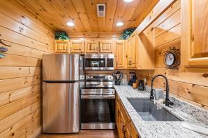 una cocina con nevera de acero inoxidable y armarios de madera en The Sly Fox - Recently Updated/ Ideal PF Location, en Pigeon Forge