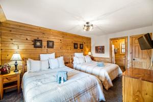 two beds in a room with wooden walls at The Sly Fox - Recently Updated/ Ideal PF Location in Pigeon Forge