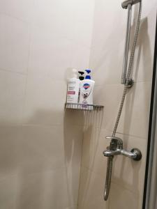 y baño con ducha y 2 botellas de jabón. en Elite Pod 807 Knightsbridge Makati en Manila