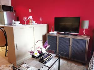 - un salon avec une télévision et une table fleurie dans l'établissement Elite Pod 807 Knightsbridge Makati, à Manille
