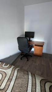 Zimmer mit einem Schreibtisch, einem Stuhl und einem Computer in der Unterkunft Chambre dans appartement près du Roazhon Park in Rennes