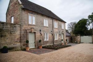 an old brick house with plants in front of it at Stable Cottage in Ashbourne