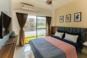 a bedroom with a bed and a large window at La vaccanza Suite -403 in Pune
