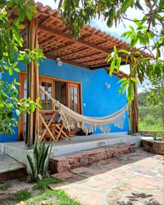 une maison bleue avec un hamac devant elle dans l'établissement A Casa Azul - Igatu, à Igatú