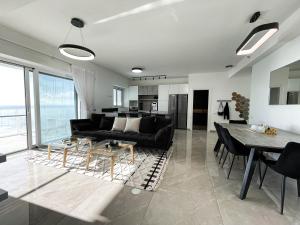 哈德拉的住宿－Sea Resort，客厅配有黑色沙发和桌子