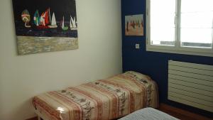 een slaapkamer met een bed en een schilderij aan de muur bij WIM GOLF in Wimereux