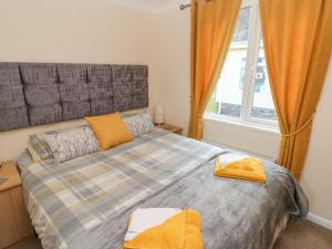 a bedroom with a bed and a window at The Hideaway - Heritage Park in Narberth