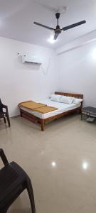 a bedroom with a bed and a ceiling fan at Mahalaxmi Guest House in Gokarna