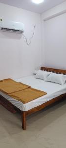 a bed in a white room with avertisementatronatronstrationstrationstration at Mahalaxmi Guest House in Gokarna