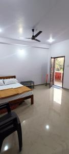 a bedroom with a bed and a ceiling fan at Mahalaxmi Guest House in Gokarna