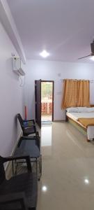 una stanza con tre sedie e un letto e una finestra di Mahalaxmi Guest House a Gokarna