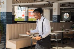 a man standing in a restaurant looking at a menu at Harbor Hotel & Casino Curacao in Willemstad