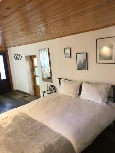 a large bed in a bedroom with wooden ceilings at Guest House Urlătoarei - Bușteni in Buşteni