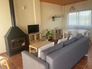 - un salon avec un canapé et une cheminée dans l'établissement Casa Rural El Olivar, à Séville