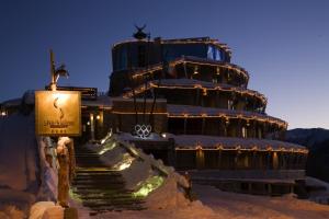 a building in the snow with stairs leading to it at Hotel Shackleton Mountain Resort in Sestriere