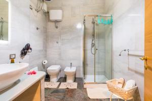 y baño con ducha, aseo y lavamanos. en Museo Filangieri Apartment-Suite, en Nápoles