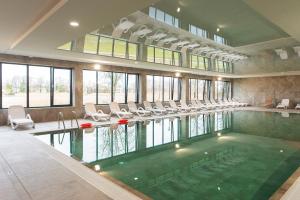 una gran piscina con sillas y una habitación grande en Apartament Dziwnów Sagaris Spa en Dziwnów