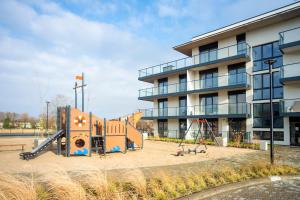 un parque infantil frente a un edificio en Apartament Dziwnów Sagaris Spa en Dziwnów