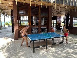 two men playing a game of ping pong at Casa da Gameleira in Baía Formosa