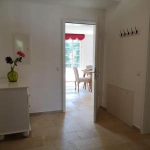 uma sala de estar com uma mesa e uma porta para uma sala de jantar em Gutshof Ferienwohnung in Seenähe em Diessen am Ammersee