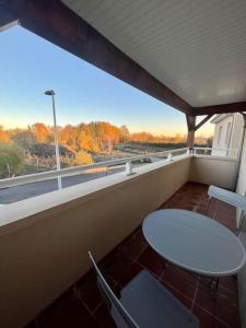 uma varanda com uma mesa e cadeiras e uma janela em Superbe appartement - DABNB em Limoges