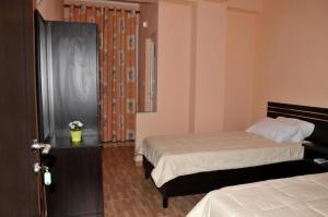 ein Hotelzimmer mit 2 Betten und einem Fenster in der Unterkunft Garden Hotel in Gjirokastër